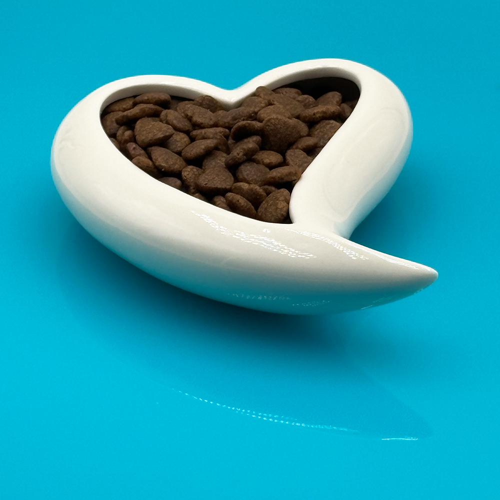 Herzförmige Schale, Katzenfutter-Trockenfutter?, Kleine braune Pellets, Trockenfutter, Dekorative Keramikschale