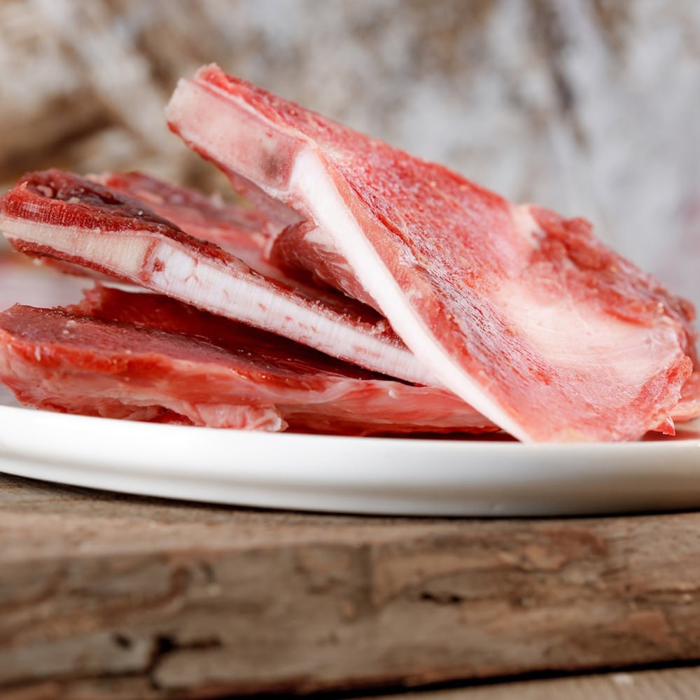 Lammkoteletts, rohes Fleisch, mit Knochen, rosa Fleisch, Teller